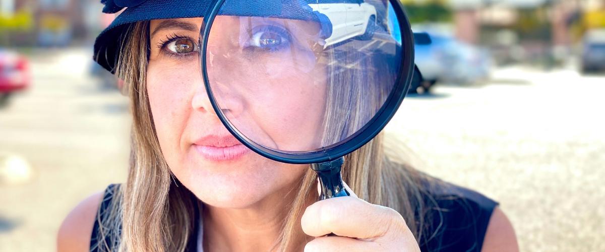 up close photo of a woman using a magnifying glass