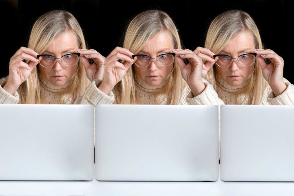 photo of a woman looking at a laptop cloned three times.
