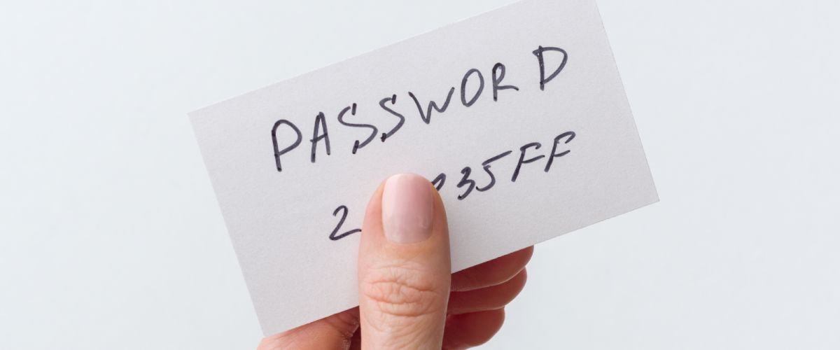 person holding paper with their password on it.