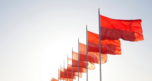 A series of red flags blowing in the wind