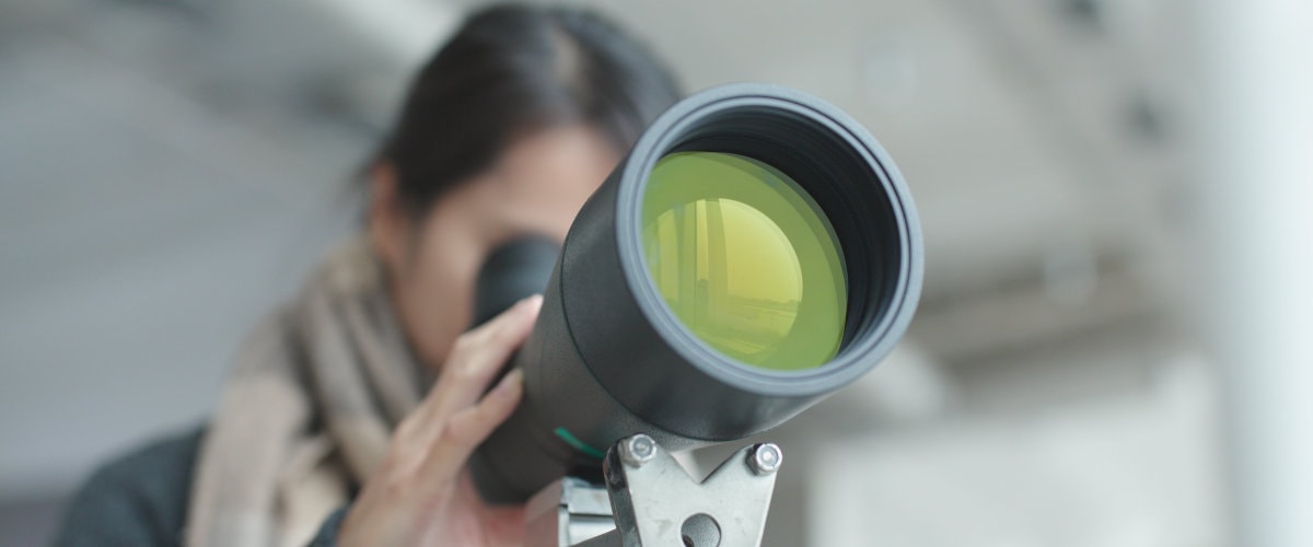 woman looking through a telescope