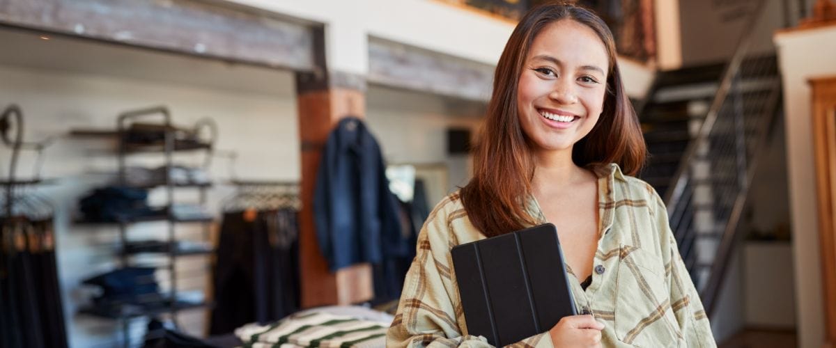 Portrait of woman holding a tablet in a clothing store