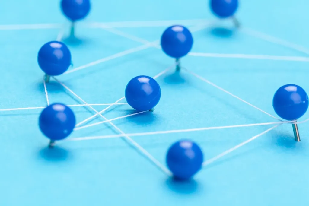 blue pins connected by string creating a demonstration of a  network